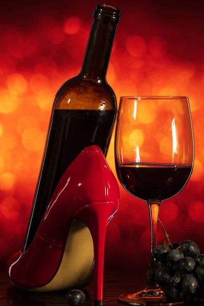 Bicchiere di vino con uva e scarpe su sfondo arancione con bo — Foto Stock