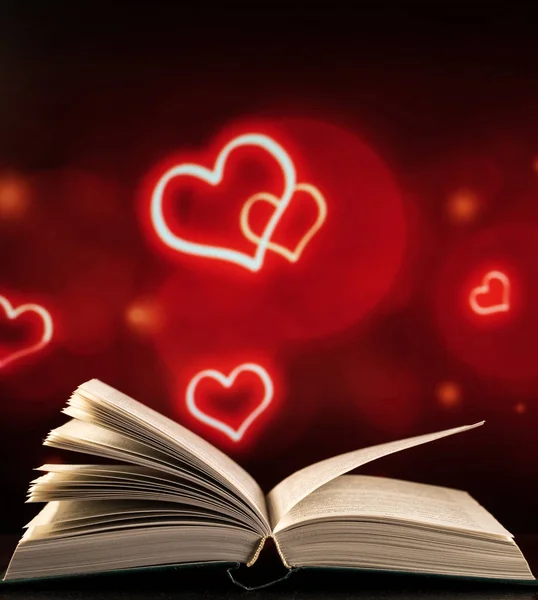 Open boek op een zwart-rode achtergrond met hartjes — Stockfoto