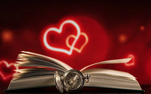 Open boek en zakhorloge op een zwart-rode achtergrond met hartjes — Stockfoto
