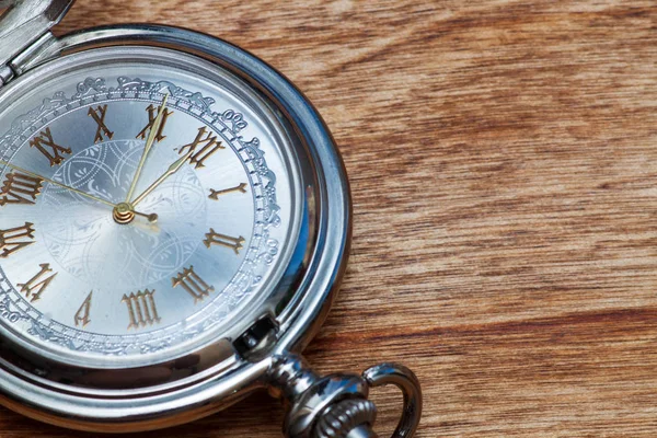 Zilveren zakhorloge op een houten tafel — Stockfoto