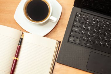 Bilgisayarı açtı, günlüğü açtı ve bir ofis masasında kahve içti.