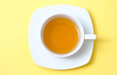 Sarı bir sırtüstü çay ile güzel beyaz bir fincan.