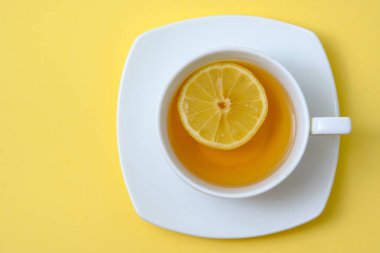 Güzel beyaz fincanlı çay ve dilimlenmiş sarı limon.