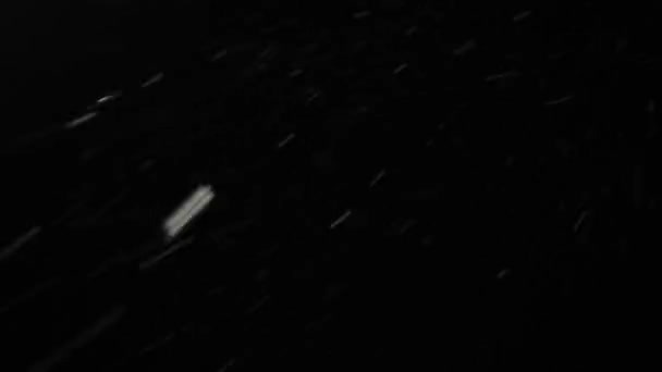 रात में तेजी से उड़ने वाली भारी बर्फ। काले आकाश के खिलाफ बर्फबारी — स्टॉक वीडियो