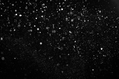 Gece gökyüzünün siyah arka planında güzel, uçuşan şiddetli kar.