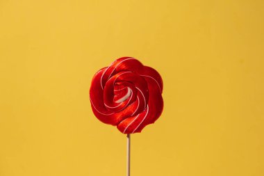 Güzel kırmızı karamelli şeker Sarı bir poponun üstünde çubuk