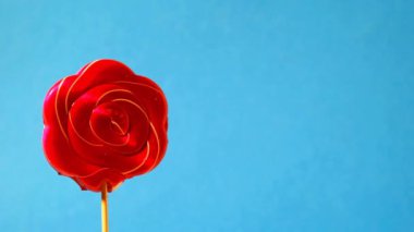 Mavi arka planda çubuk üzerinde kırmızı karamel şekeri