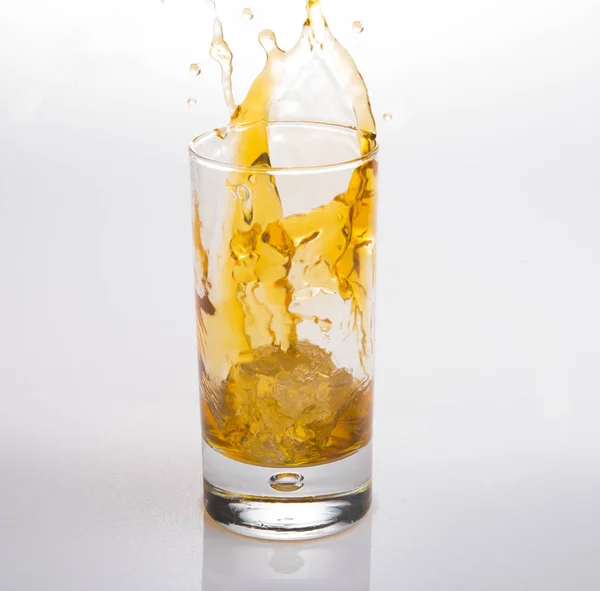 Splash Of Whisky em um fundo branco — Fotografia de Stock