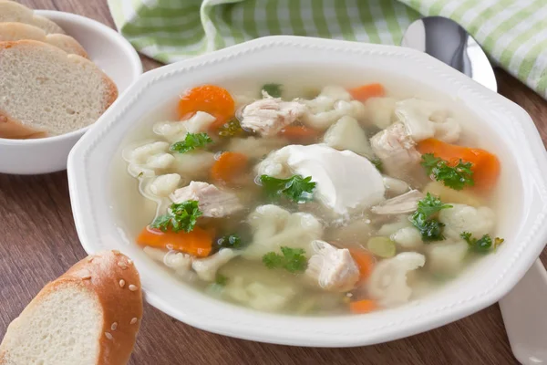Suppe mit Huhn, Blumenkohl, Gemüse und Brot auf weißem Teller — Stockfoto