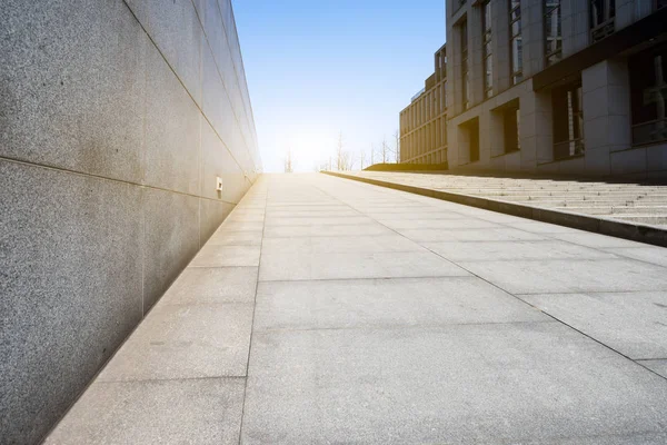 Fußweg zwischen modernem Gebäude mit Sonnenstrahl — Stockfoto