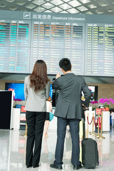 back of girl and businessman in airport