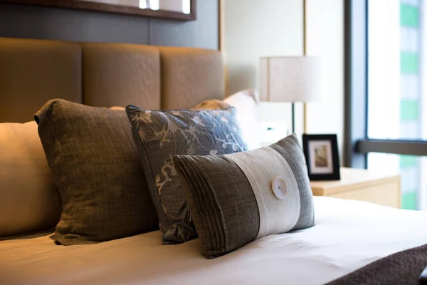 Travesseiros em cama confortável no quarto moderno — Fotografia de Stock