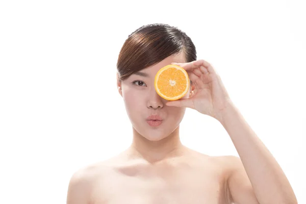 Gesichtsbehandlung der asiatischen Frau mit Orange — Stockfoto