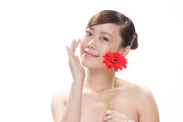 Ansigtsbehandling makeup af asiatisk kvinde med blomst - Stock-foto