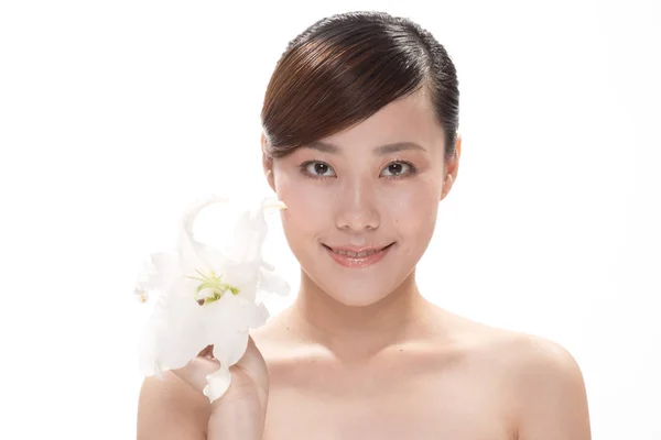Gesichtsbehandlung der asiatischen Frau mit Blume — Stockfoto