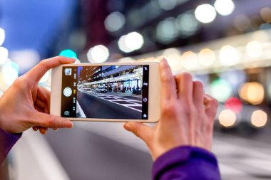 kadın fotoğrafı cep telefonuyla çeker.