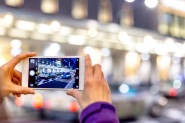 kadın fotoğrafı cep telefonuyla çeker.
