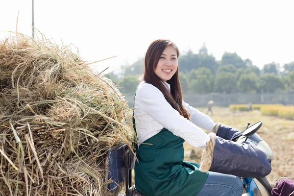 Mulher agrônomo em motocicleta com palha dourada — Fotografia de Stock