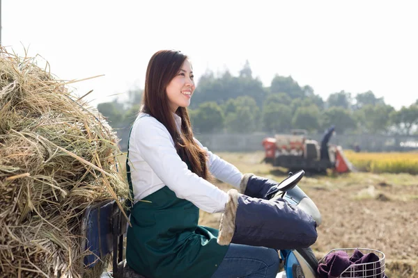 Mulher agrônomo em motocicleta com palha dourada — Fotografia de Stock