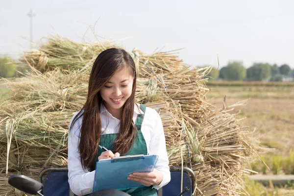 Woman agronomist working on motocycle with straw — Stock Photo, Image