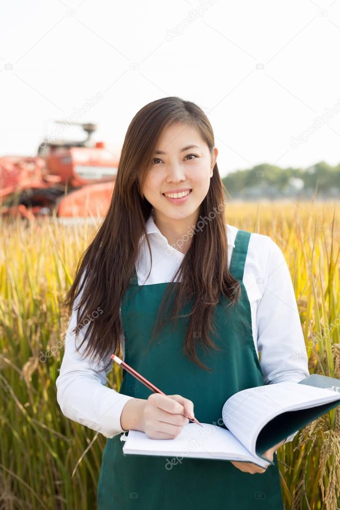 woman agronomist in cereal field with harvester