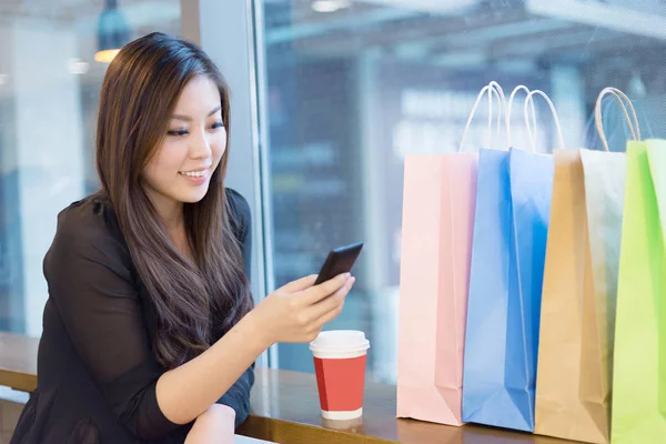 woman with mobile phone in shopping mall