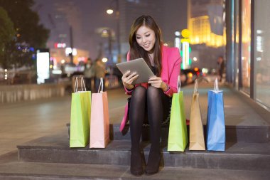 tablet ve alışveriş torbaları gece kadın ile