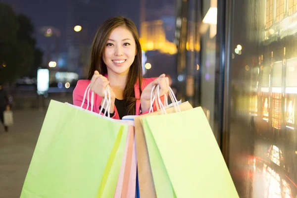 Woman with shopping bags at night — Stock Photo, Image