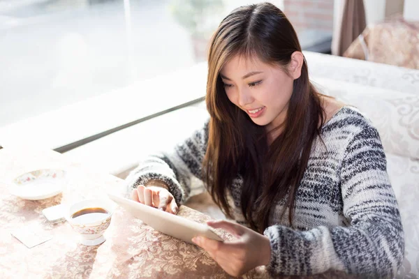 Νεαρή Κινέζα με tablet σε καφετέρια — Φωτογραφία Αρχείου