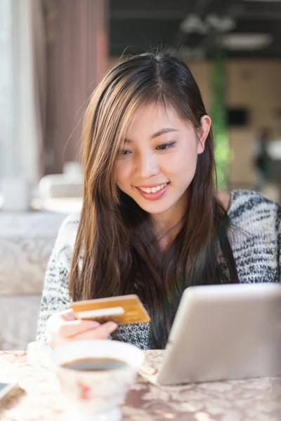 Vrouw met creditcard en tablet in café — Stockfoto