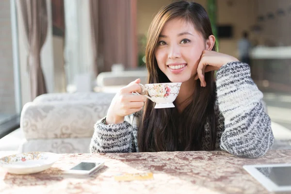Jonge mooie chinese vrouw in café — Stockfoto
