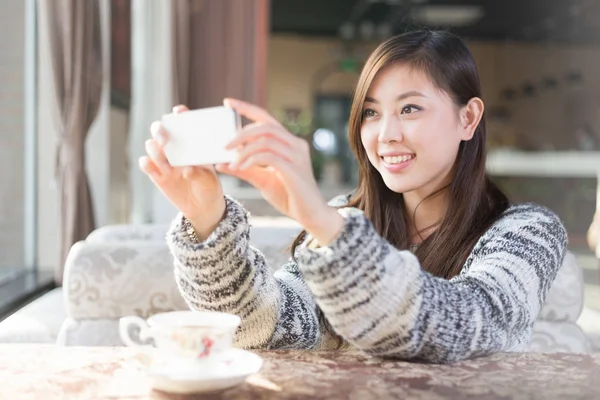 移动电话在咖啡馆里的中国女人 — 图库照片