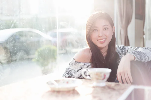 Jonge mooie chinese vrouw in café — Stockfoto