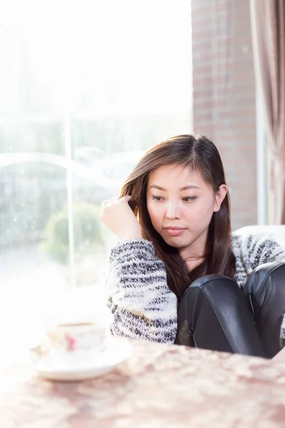 Jonge mooie chinese vrouw in café — Stockfoto