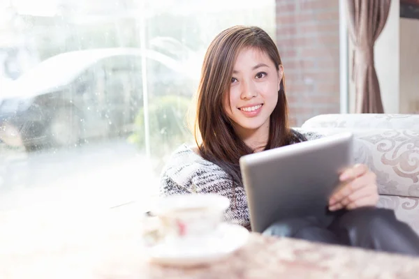 Jonge chinese vrouw met tablet in café — Stockfoto