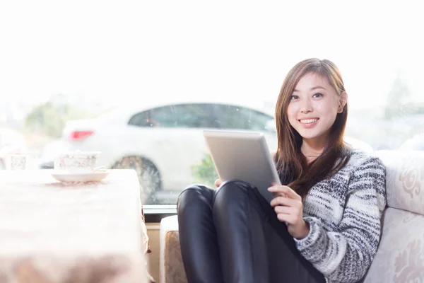 Jonge chinese vrouw met tablet in café — Stockfoto