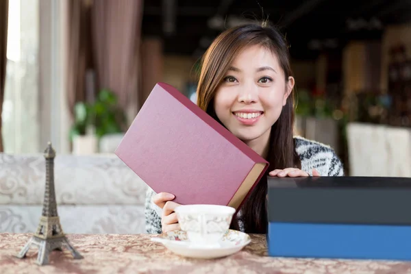 young chinese woman with books in cafe