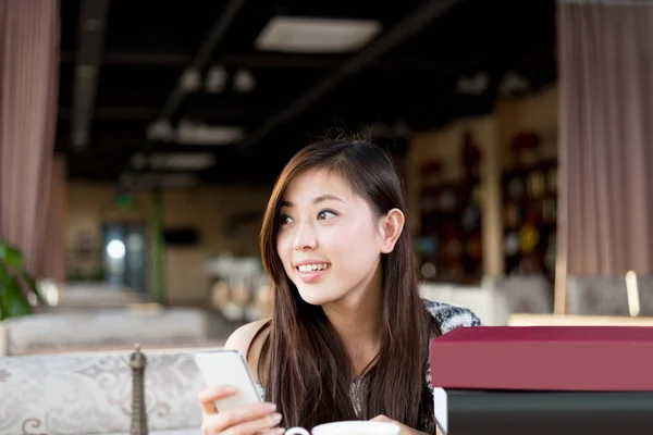 Mujer china con teléfono móvil en la cafetería —  Fotos de Stock