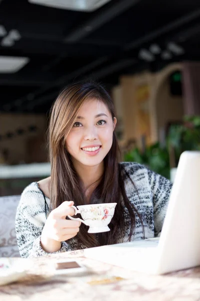 Unga kinesiska kvinna med laptop i café — Stockfoto