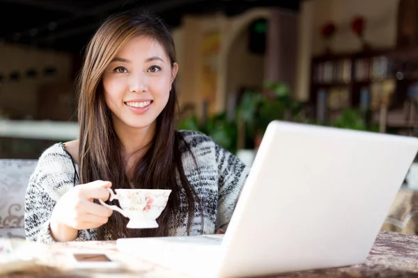 Unga kinesiska kvinna med laptop i café — Stockfoto
