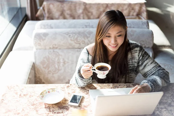 Unga kinesiska kvinna med laptop i café — Stockfoto