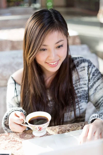Kafede dizüstü bilgisayar ile genç Çinli kadın — Stok fotoğraf