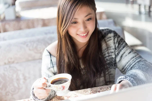 Молодая китаянка с ноутбуком в кафе — стоковое фото