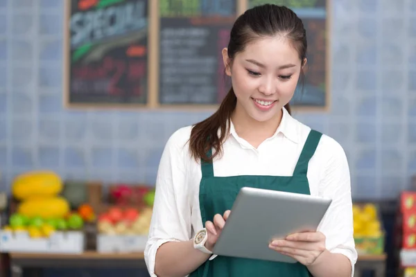 Pretty woman works in fruit store — Stock Photo, Image