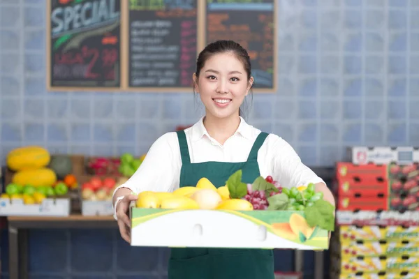 pretty woman works in fruit store