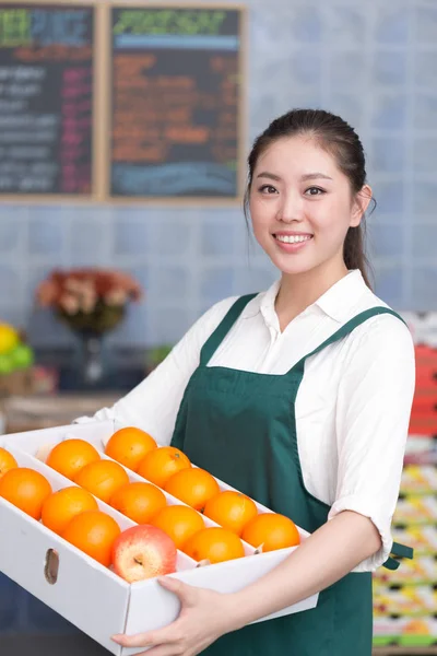 pretty woman works in fruit store