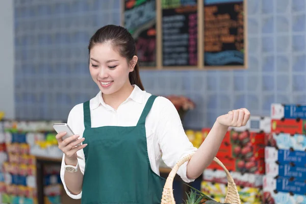 pretty woman works in fruit store