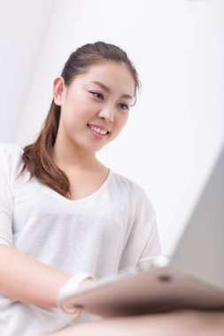 güzel kadın kanepede dizüstü bilgisayar kullanarak