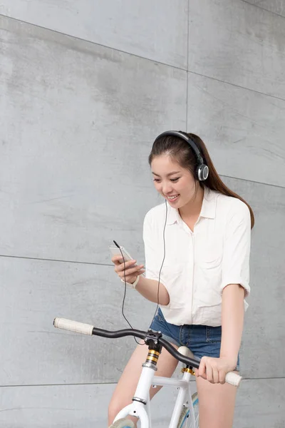 chinese woman listening music with bike