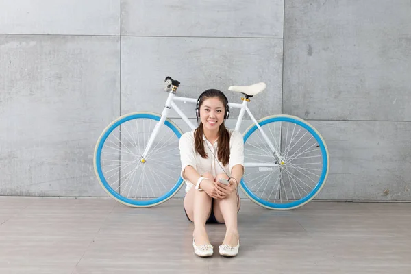 Donna cinese che ascolta musica con bici — Foto Stock